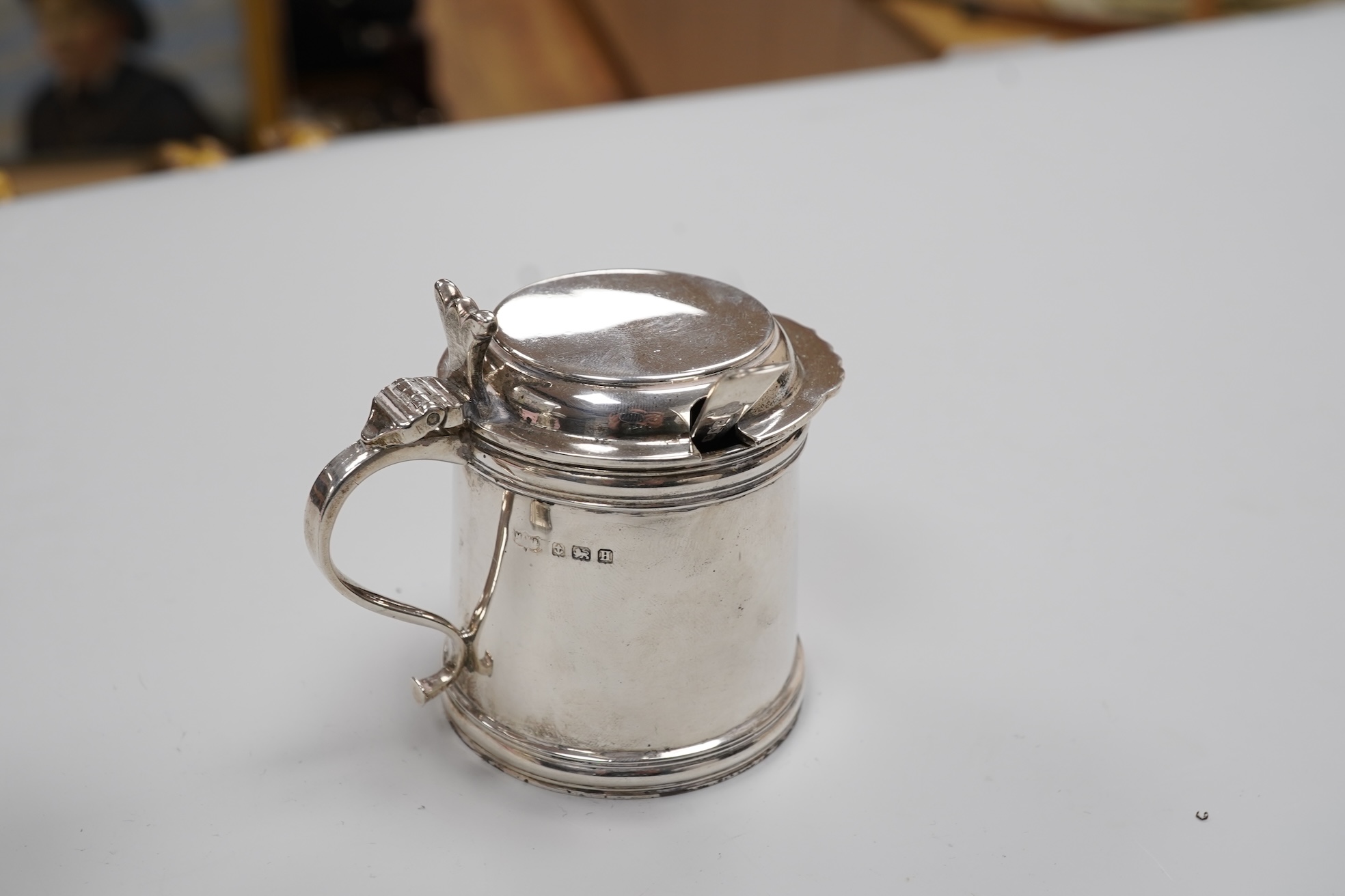 A George V silver drum mustard by Mappin & Webb, Birmingham, 1923, height 71mm, with associated spoon, together with a pair of George V silver pepperettes, Adie Brothers, Birmingham, 1923.